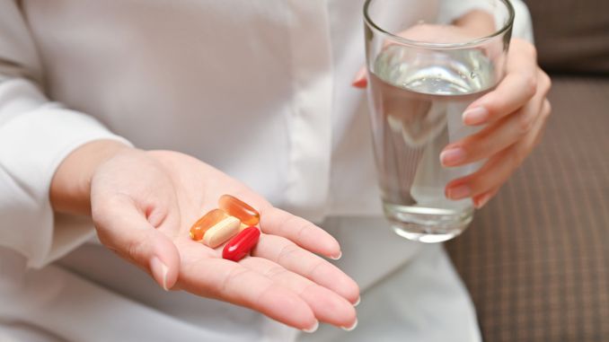 holding-pill-glass-water - Supplements Mental Health Benefits